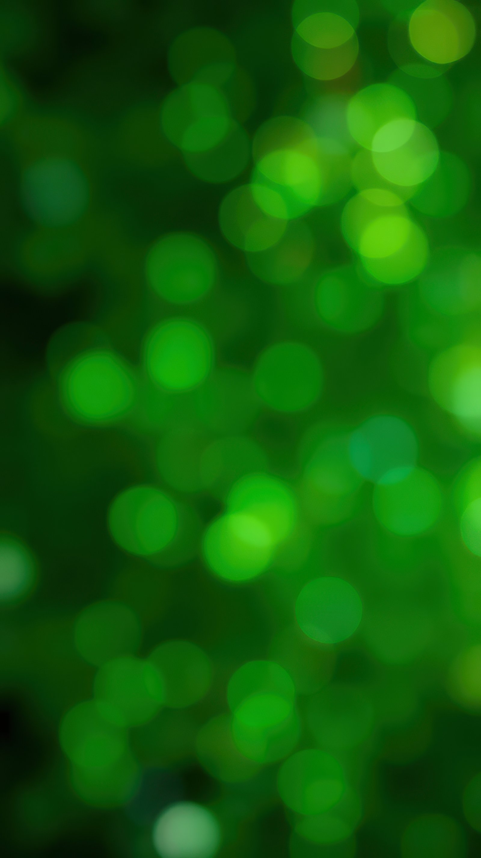 Vibrant green bokeh lights create a shimmering effect in the background during a festive celebration at night